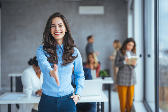 Welcome! Portrait of friendly hospitable cheerful woman giving hand to handshake, hostess greeting guest. Happy office employee giving hand for shaking