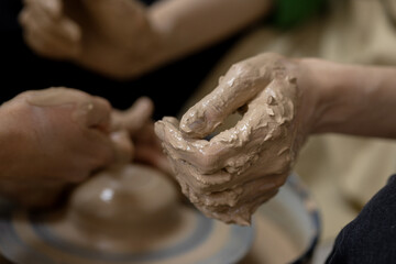 A woman's hand in clay after starting work on a potter's wheel. Close-up