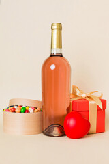 Bottle of wine on colored background for Valentine Day with gift box. Heart shaped with presrnt box perspective view with copy space