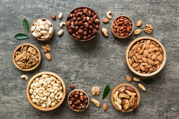mixed nuts in wooden bowl. Mix of various nuts on colored background. pistachios, cashews, walnuts, hazelnuts, peanuts and brazil nuts