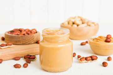 Bowl of peanut butter and peanuts on table background. top view with copy space. Creamy peanut pasta in small bowl
