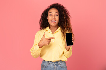 Happy black woman pointing at smartphone and smiling