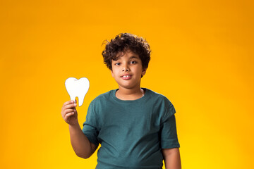 Child boy holding papercraft tooth. Dental health concept