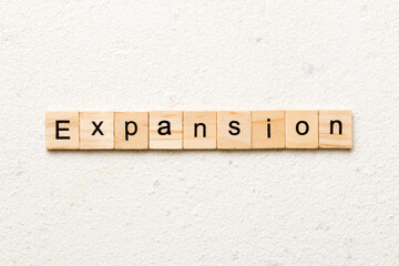 expansion word written on wood block. expansion text on table, concept