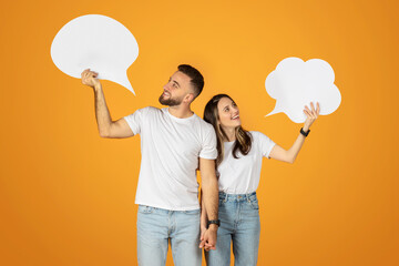 A young man and woman smilingly hold up blank speech bubbles, symbolizing communication or dialogue