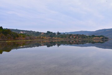 Mediterranean coast of the Adriatic sea at Strunjan with a reflection of the hill with buildings in Primorska, Slovenia