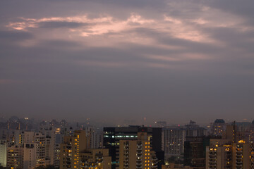 Gurgaon,Haryana,India colorful sunset on a foggy winter evening.Aerial view of Gurugram urban cityscape with modern architecture,commercial ,luxury residential apartment buildings.Delhi NCR.