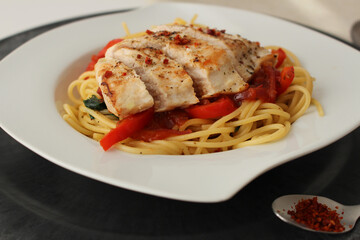 Fresh cooked breast of turkey with peppers and spaghetti aglio e olio 