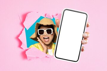 asian woman showing smartphone mockup screen through ripped pink paper - obrazy, fototapety, plakaty