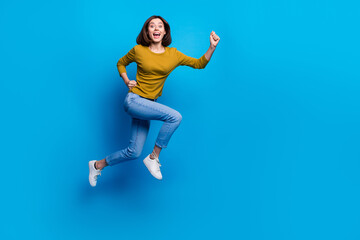 Full length photo of pretty cheerful lady dressed shirt jumping high running fast empty space isolated blue color background