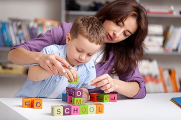 Obraz premium Teacher learning little child in classroom. Preschool education concept