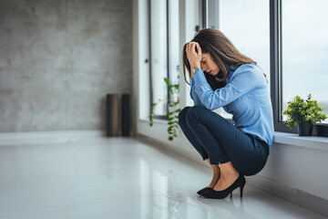 Shot of an attractive young businesswoman sitting alone in the office and feeling stressed. Shot of a young businesswoman experiencing stress while working