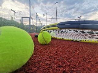 Tennis racket and ball on a hard tennis court