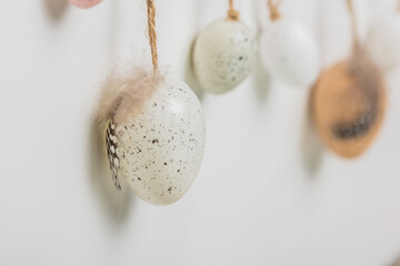 Colorful Easter eggs hanging on a string against a white background. Ideal for Easter-themed marketing materials or holiday greeting cards.