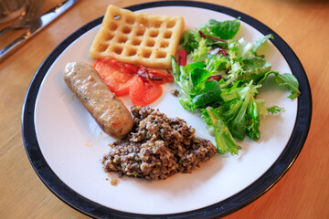 A Balanced Meal: Fresh Salad, Savory Meat, and Golden Waffles