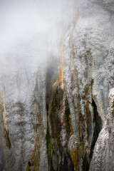 gray and yellow stone texture at rotorua geyser in new zealand with fog