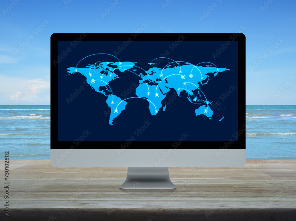 Poster connection line with global world map on computer monitor screen on wooden table over tropical sea a