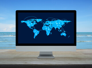 Connection line with global world map on computer monitor screen on wooden table over tropical sea and blue sky, Technology communication online concept, Elements of this image furnished by NASA