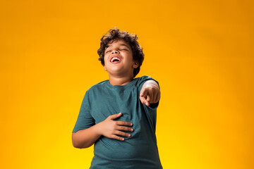 Kid boy mocking and teasing at someone showing finger at camera and holding stomach. Bulling concept - obrazy, fototapety, plakaty