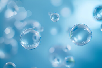 An artistic representation featuring a collection of transparent and glossy bubbles or droplets. They are floating against a soft blue background, creating a serene and ethereal atmosphere.