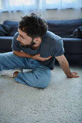 Obraz premium bearded suffering man in casual home wear having severe panic attack, mental health awareness