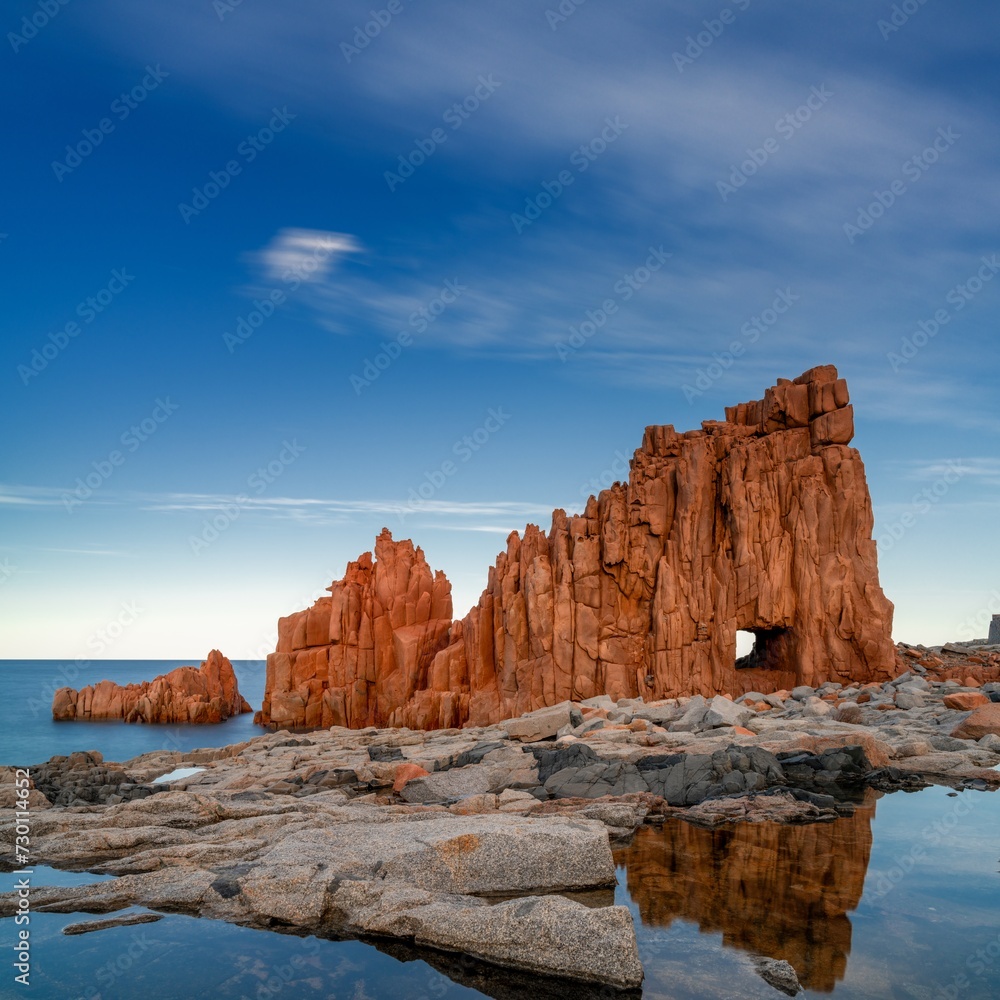 Sticker view of the red rocks of Arbatax with reflections in tidal pools in the foreground