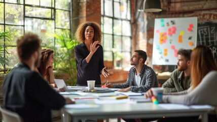 business woman giving a presentation in front of a group of attentive colleagues in a modern office environment