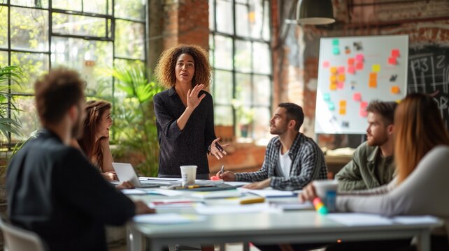 business woman giving a presentation in front of a group of attentive colleagues in a modern office environment