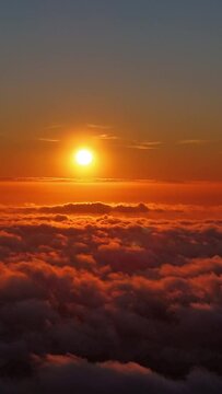 Aerial vertical timelapse over the clouds while sunset transforming into night