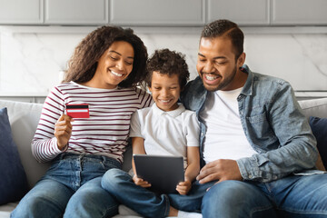Black Family Shopping Online With Digital Tablet And Credit Card At Home