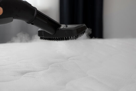 Cleaning and disinfection of the mattress in the bedroom with hot steam