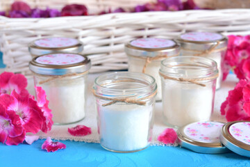 Wedding favors candles in glass jar and jute ribbon, small guest gifts, white blue background, pink flowers colorfull spring summer cheerful style weddings party souvenirs, ceremony decoration ideas