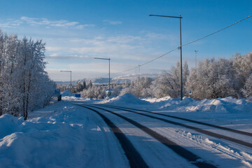 Idyllic panoramic view of a beautiful white winter wonderland scenery in Scandinavia with scenic golden evening light at sunset in winter, northern Europe.