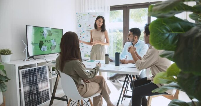 Asian woman lead young group of multiethnic businesspeople in team meeting, using laptop computer for ESG topic presentation on monitor. Sustainable business practice, people work at home concept