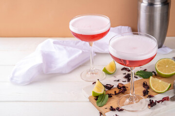 Hibiscus sour alcoholic cocktail, mocktail, hibiscus martini margarita drink with ice, lime and mint on a light background