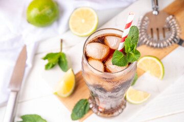 Cuba Libre or long island iced tea cocktail with strong drinks, cola, lime and ice in glass, cold long drink or lemonade