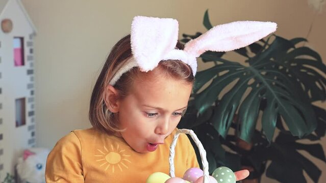 Easter egg hunt. Excited emotion surprise adorable child girl in bunny ears rabbit costume hold basket with Easter colored eggs. Children positive emotions. Kid happy Easter