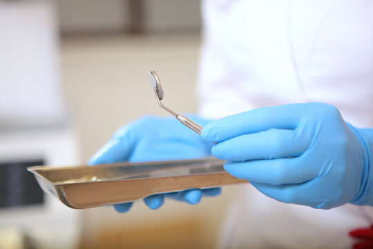 Dental instruments in the hands of an assistant. Modern dentistry.