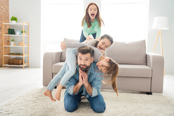 Portrait of lovely funny cheerful family playing daddy piggy backing spending holiday at home house...