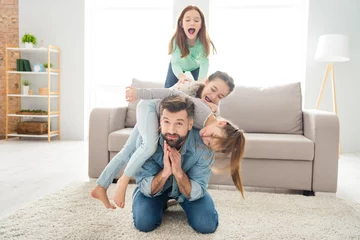Fotobehang Portrait of lovely funny cheerful family playing daddy piggy backing spending holiday at home house living-room indoors © deagreez
