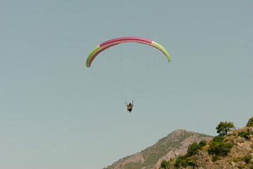 Pilot and passenger paragliding on sunny day