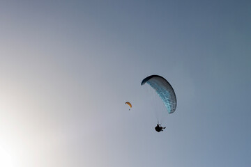 Colourful paragliders against sky