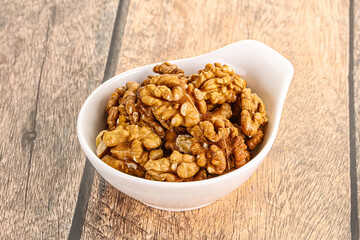 Cracked unshelled walnut in the bowl