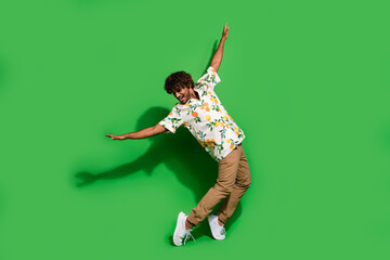 Full length photo of funky cheerful latin guy dressed print shirt dancing disco isolated green color background