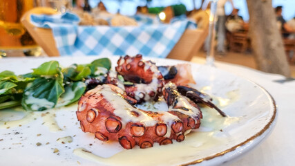 Closeup of a grilled octopus dish in a Greek taverna restaurant.
