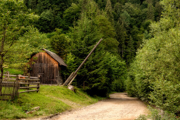 village street in green mountains. old wooden barn along the road. Carpathian mountains.