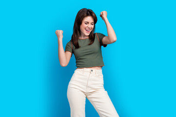 Portrait of overjoyed positive lady raise fists closed eyes shout yes isolated on blue color background