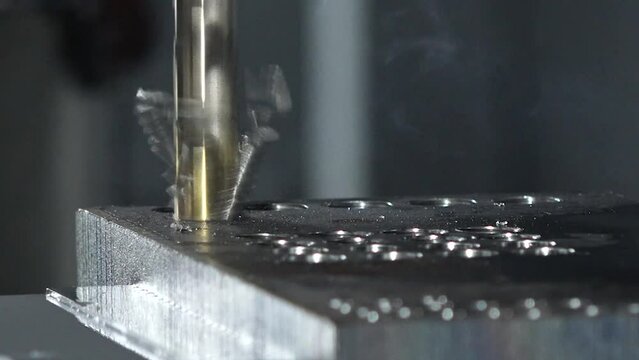 CNC drilling machine drill holes into metal surface , close up