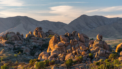 A mountain range with a rocky terrain and a sunset in the background. © Dan Van Pelt