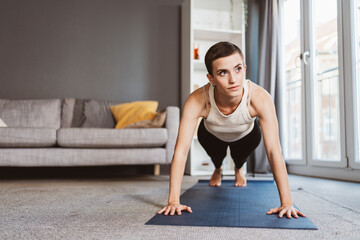 Young Sporty Woman Doing Push-Ups with Determination in her Home